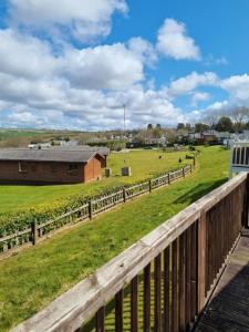 a view of a farm with a fence and a field at Bella View - Newquay - White Acres in Newquay