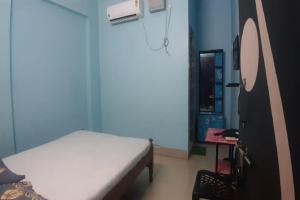a hospital room with a bed and a mirror at Goroomgo Om Sai Residency Bhubaneswar in Bhubaneshwar