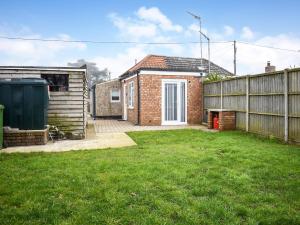 a yard with a fence and a house at The Snuff Box in Clenchwarton