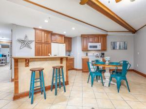 a kitchen with a table and some blue chairs at Colony 221 in Tybee Island