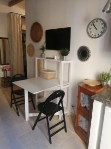 Le Tre Terrazze في بولونيا: طاولة بيضاء وكراسي في غرفة بها ساعة
