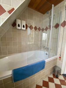 a bathroom with a tub with a glass shower at B&B Zonnedael in Oosterend