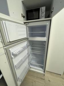 um frigorífico vazio com um micro-ondas na cozinha em Chic Studio em Onesti