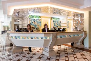Dos mujeres sentadas en un mostrador en un restaurante en Hotel Hermitage, en Galatina