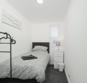 a white bedroom with a bed and a window at Apex Living NE - Carnegie House 4 Bed House, FREE PARKING FREE WiFi 