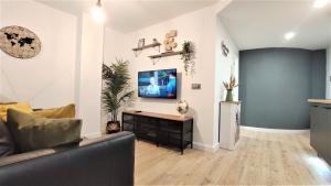 uma sala de estar com um sofá e uma televisão na parede em Apartamento María - precioso y tranquilo loft en pleno centro em Múrcia