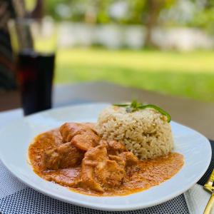 een bord eten met kip en rijst op een tafel bij Upper Hill Place in Dar es Salaam