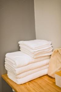 a stack of white towels sitting on a wooden shelf at Royce Boutique Betong in Betong