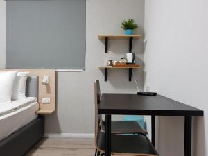 a bedroom with a desk and a bed and a table at Airport Guest House in Or Yehuda