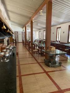 a dining room with tables and chairs in a restaurant at Zeenath Taj Gardens in Yelagiri