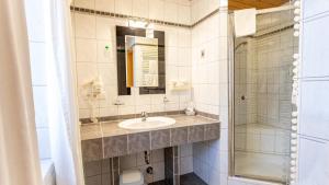 a bathroom with a sink and a shower at Aktivhotel & Gasthof Schmelz Ihr Urlaubs Hotel in Inzell mit Wellness Hallenbad, Alpensauna & Dampfbad in Inzell