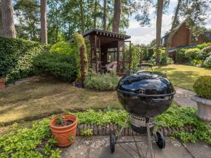 a grill sitting in a yard next to a garden at High Trees in Bodham