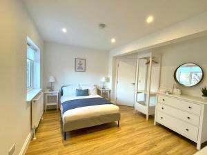 a bedroom with a bed and a dresser and a mirror at Ivory House in Gorleston-on-Sea
