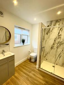 a bathroom with a shower and a toilet and a sink at Ivory House in Gorleston-on-Sea