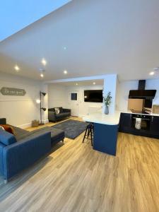 a large living room with a blue couch and a kitchen at Ivory House in Gorleston-on-Sea