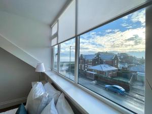 a bedroom with a large window with a view at Ivory House in Gorleston-on-Sea