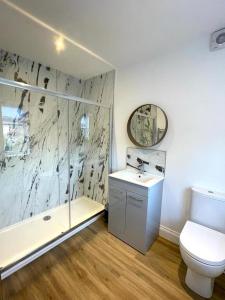 a bathroom with a toilet and a sink and a shower at Ivory House in Gorleston-on-Sea