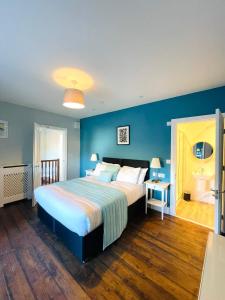 a bedroom with a large bed and a blue wall at Coral House in Gorleston-on-Sea