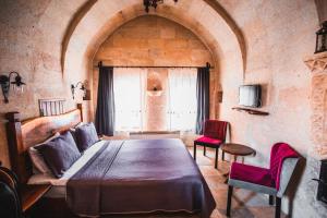 a bedroom with a large bed in a stone room at APEX CAVE HOTEL in Göreme