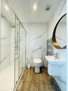 a bathroom with a toilet and a sink and a shower at Coral House in Gorleston-on-Sea