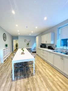 a large kitchen with a white table in a room at Coral House in Gorleston-on-Sea