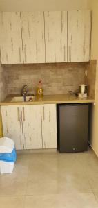 a kitchen with white cabinets and a black dishwasher at במרכז הכפר in Majdal Shams