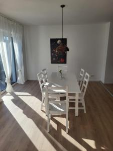 Apartment in Plankstadt في Plankstadt: غرفة طعام بيضاء مع طاولة بيضاء وكراسي