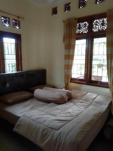 Bett in einem Zimmer mit zwei Kissen darauf in der Unterkunft Nyaman in Bogor