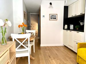 a kitchen with white cabinets and a table and chairs at Les Petits Volets 3 appartements au choix in Antibes