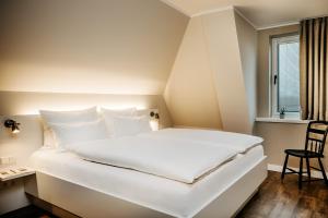 a large white bed in a room with a window at Seaside 43 in Sankt Peter-Ording
