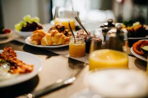 a table topped with plates of food and orange juice at Seaside 43 in Sankt Peter-Ording
