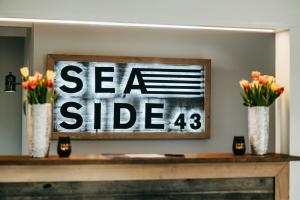 a sign on top of a table with flowers in vases at Seaside 43 in Sankt Peter-Ording