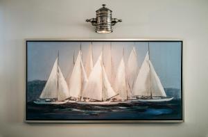 a painting of white sailboats on the water with a light at Seaside 43 in Sankt Peter-Ording