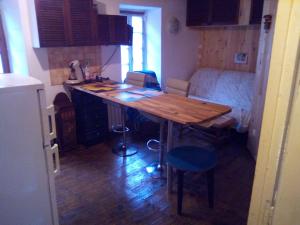 Petit village authentique في Mauléon-Barousse: مطبخ صغير مع طاولة خشبية في الغرفة