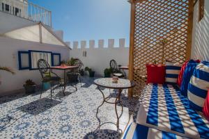 a patio with tables and chairs in a room at Riad Dar Abi in Essaouira