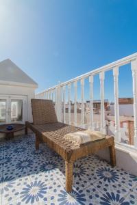 a bench on a balcony with a view of the ocean at Riad Dar Abi in Essaouira