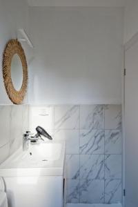 a white bathroom with a sink and a mirror at Isla apartment's in Tel Aviv