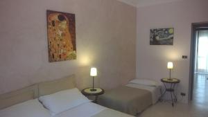 a hotel room with two beds and two lamps at Lingotto in Turin