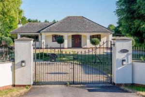 a house with a gate in front of a house at Honeyacres in Down Hatherley