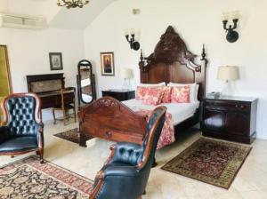 een slaapkamer met een bed, een stoel en een piano bij Waterkloof Mansion Boutique Hotel in Pretoria