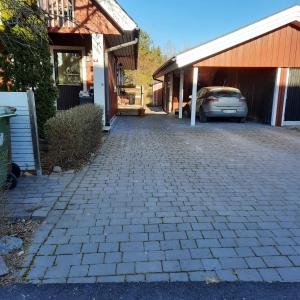 a driveway with a car parked next to a building at Naturnära dubbelrum B&B i Uppsala Ramstalund in Uppsala