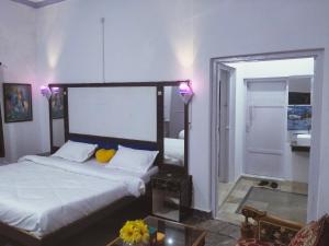 a bedroom with a large bed and a mirror at Eastern Gate Homestay in Khajurāho