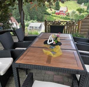 a wooden table on a patio with chairs at Hotel zur Schmiede in Altenau