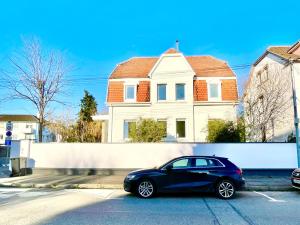 a black car parked in front of a house at Charmante maison - centre-ville Colmar in Colmar