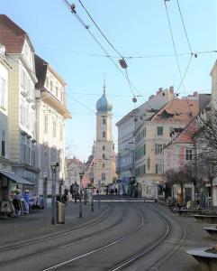 a city street with a clock tower in the distance w obiekcie Romantik Apartment Graz w Grazu