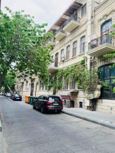 a car parked on a street in front of a building at beautiful and comfortable apartment in the city center in an architectural building in Baku