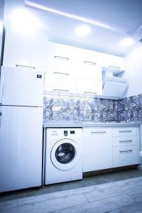 a washer and dryer in a kitchen with white cabinets at beautiful and comfortable apartment in the city center in an architectural building in Baku
