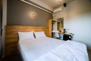 a bedroom with a white bed and a desk at Royce Boutique Betong in Betong