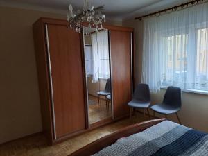 een slaapkamer met een grote spiegel en 2 stoelen bij Apartment Rose in Jesenice