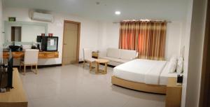 a bedroom with a bed and a desk and a television at PUNTA CLARK HOTEL in Clark